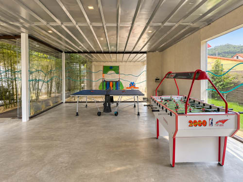 Sala de recreación moderna en el resort de playa ModulSenses en Baiona con futbolín, tenis de mesa y arte mural colorido