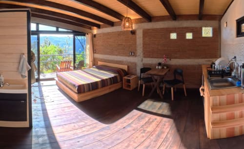 Habitación loft con cama Queen y vistas a la montaña en Sento SanMa, con vigas de madera, balcón, kitchenette y piso de madera
