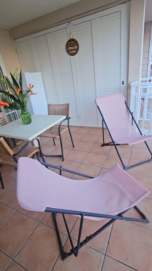 Chaises longues roses sur la terrasse de Ti Oasis, Sainte-Luce, avec vue sur la piscine et la mer