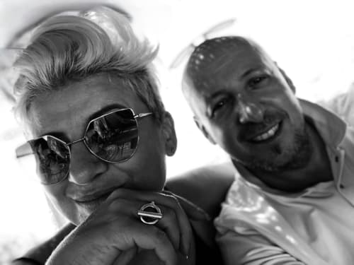 Two men smiling at Jardin Sakina B&B in Marrakech, wearing sunglasses in black and white