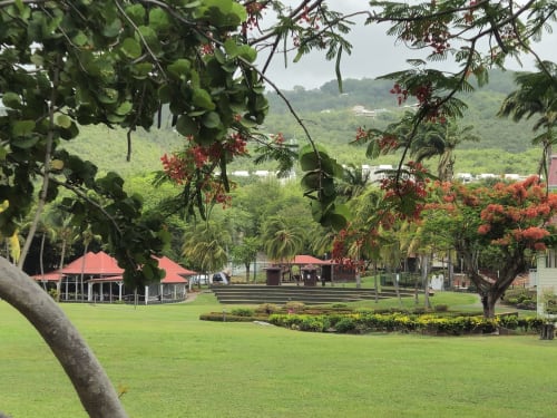Jardin tropical de Ti Oasis Sainte-Luce avec pavillons aux toits rouges, verdure luxuriante et vues sur les montagnes