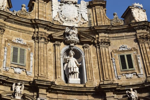 Elegante facciata in pietra del BnB del Parlamento a Palermo con dettagli architettonici classici, sculture e ornamenti decorativi