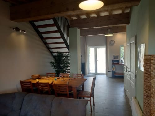 Domaine Le Piboul dining area with wooden table, staircase, and modern lighting in Fontcouverte