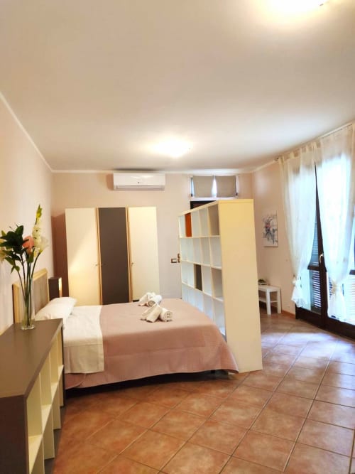 Spaziosa camera da letto a La Piazzetta Signa con letto, ripostigli, pavimento in terracotta e porte con vista sul giardino a Signa, Italia