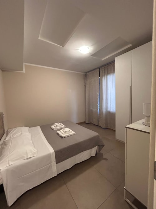 Camera da letto moderna dell'appartamento La Piazzetta Signa a Signa con letto, biancheria bianca e design del soffitto contemporaneo