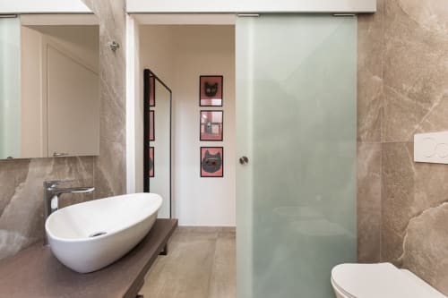 Bagno moderno negli LM Apartments Pavia con lavabo ovale, box doccia in vetro satinato e pareti in piastrelle beige
