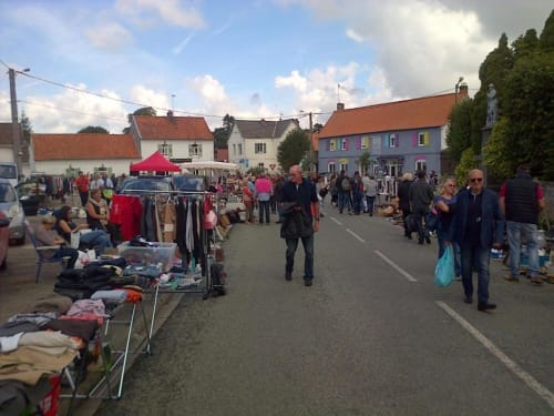 Festival de marché en plein air à Beussent, France avec des bâtiments colorés et des étals de vendeurs