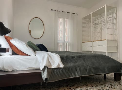 Camera moderna agli LM Apartments Pavia con vista città, letto, specchio rotondo, guardaroba e luce naturale