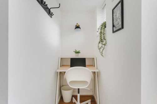 Modern workspace nook with white desk chair, potted plants, and pendant lighting in Stevenage villa