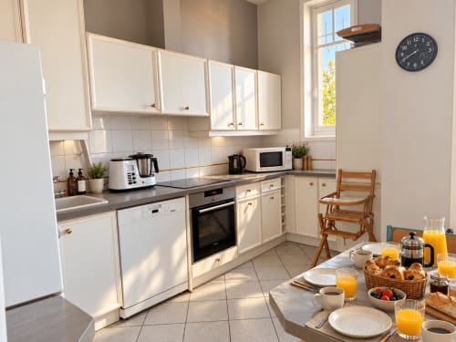 Cuisine lumineuse de la Villa Cognehors, ARLOÉ La Rochelle, avec table de petit-déjeuner dressée et vue sur le jardin