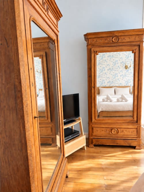 Chambre élégante de la villa ARLOÉ à La Rochelle, avec armoire en bois ouvragé et portes miroir