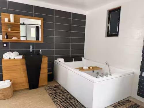 Salle de bain contemporaine à la Villa Alba d'ARLOÉ, La Rochelle, avec baignoire îlot blanche et carrelage noir