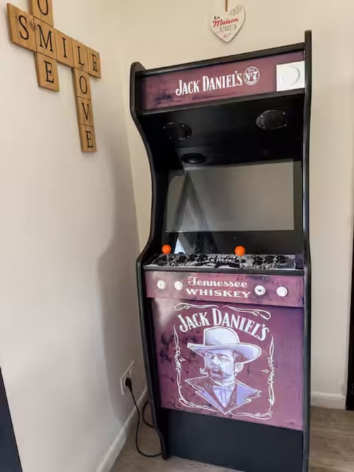 Borne d'arcade Jack Daniel's à Villa Alba, hôtel ARLOÉ à La Rochelle, avec panneau sourire décoratif en bois