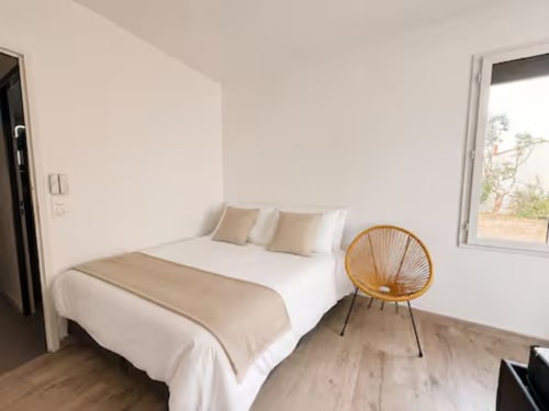 Chambre Villa Alba avec lit queen-size, fauteuil orange et vue océan à ARLOÉ La Rochelle