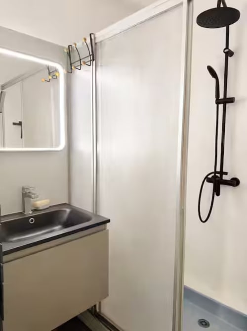 Salle de bain moderne à la Villa Alba d'ARLOÉ La Rochelle avec système de douche noir et miroir rétroéclairé