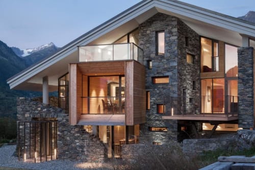 Chalet Violettes, luxueux chalet alpin à Villaroger avec façade en pierre, fenêtres modernes et vue montagne au crépuscule