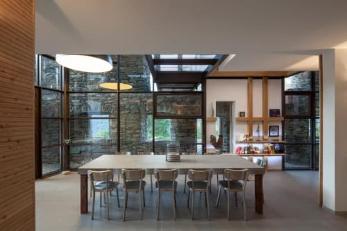 Salle à manger moderne du Chalet Violettes avec murs en pierre, accents bois et puits de lumière à Villaroger