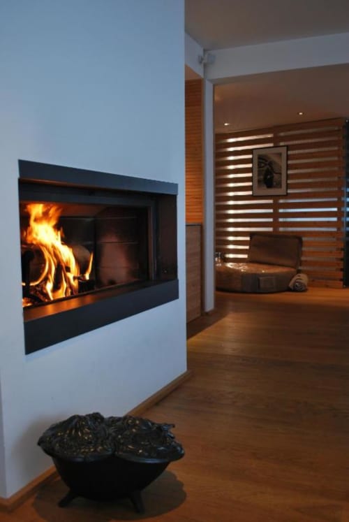 Foyer moderne avec feu flamboyant au Chalet Violettes à Villaroger, France, sol en bois et style contemporain