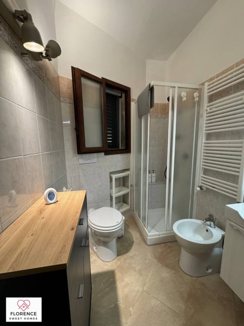 Bagno moderno a Florence Sweet Homes con vanità in legno, doccia, bidet, scaldasalviette e piastrellatura in marmo