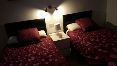 Camas gemelas con ropa de cama estampada en borgoña en Hostal Fornet Altea, habitación doble con vistas a la montaña y servicios modernos