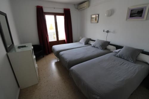 Habitación triple con tres camas en Hostal Fornet Altea, TV, aire acondicionado y balcón con vistas a las montañas