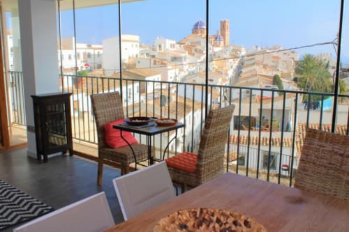 Zona de estar en balcón del Hostal Fornet Altea con vistas al pueblecito costero mediterráneo, campanario y tejas de barro