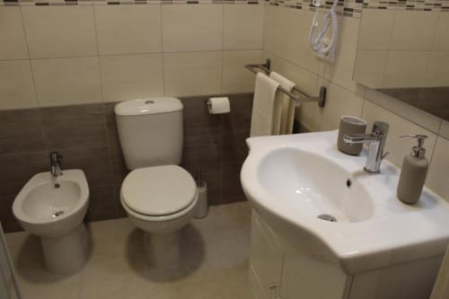 Bagno moderno della U Baruni b&b Messina con bidet, wc, lavabo e vasca da bagno bianchi