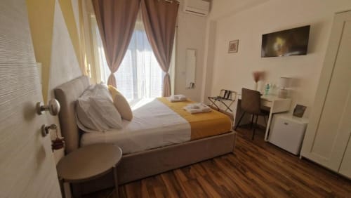 Camera doppia con balcone all'U Baruni b&b di Messina: letto matrimoniale, vista città, TV, scrivania e pavimento in legno
