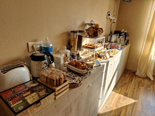 Colazione continentale a buffet presso U Baruni B&B a Messina con pasticcini, pane, cereali e bevande su bancone bianco