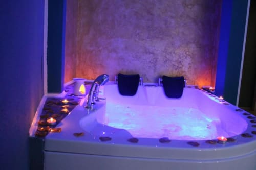 Vasca idromassaggio di lusso con illuminazione viola e candele presso l'U Baruni B&B a Messina, Italia