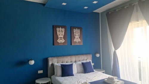 Camera moderna presso U Baruni b&b a Messina con pareti blu, letto matrimoniale, tende bianche e balcone con vista sulla città