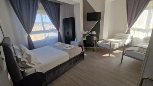 Camera Familiare presso U Baruni b&b a Messina con letto matrimoniale, letti singoli, finestre con vista sulla città, TV e comfort moderni