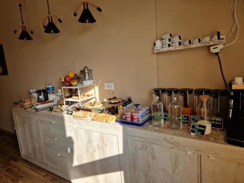 Il banco colazione di U Baruni b&b a Messina con dolci, bevande e lampade a sospensione