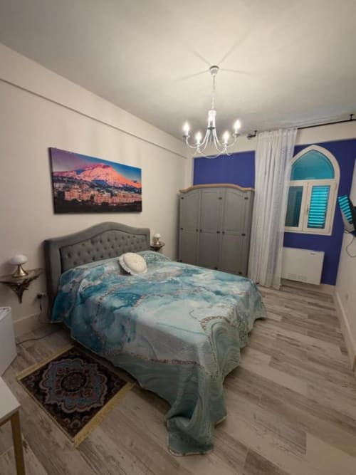 Camera Doppia 2 a Villa Brikinnia a Lentini con biancheria azzurra, testata grigia, lampadario e parete blu