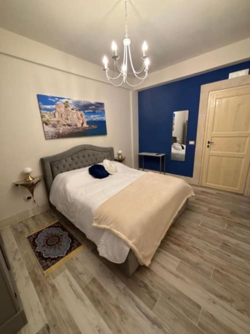 Camera moderna di Villa Brikinnia a Lentini con letto queen, parete azzurra e lampadario