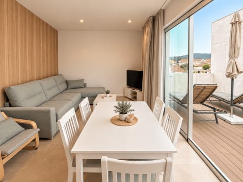 Elegante apartamento de 2 dormitorios con comedor, sofá y terraza con vistas a la ciudad en Holibai, Baiona