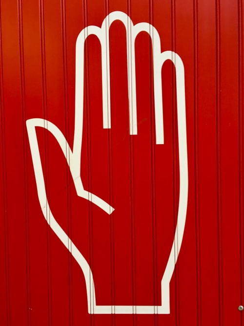 Symbole de main d'arrêt blanche sur mur ondulé rouge à la Comme Une évidence B&B, Trevignin France