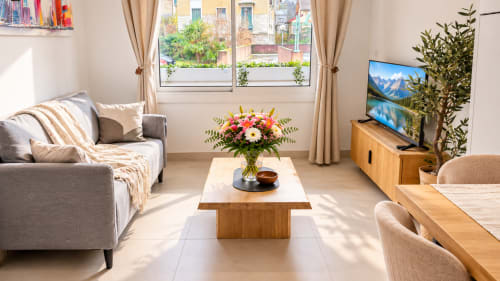 Studio lumineux au 9 Victor Hugo à Aix-les-Bains avec mobilier moderne, fleurs, télévision et vue sur la ville