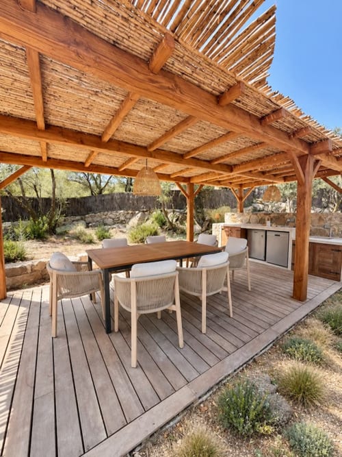 Espace salle à manger sous pergola en bois avec table et chaises à la villa Les Villas d'A Storia à Porto-Vecchio