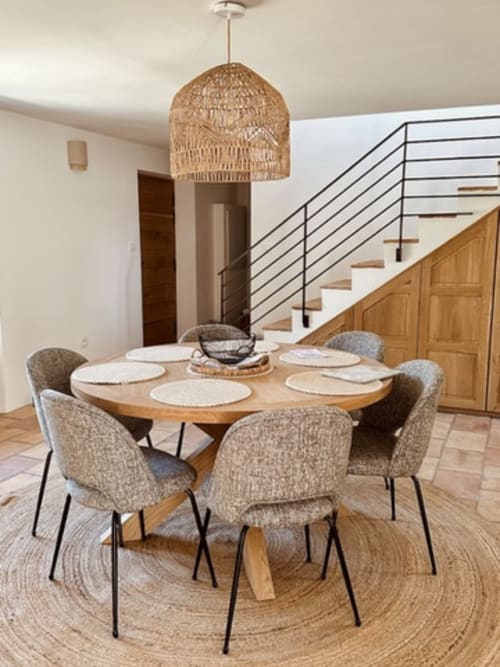 Salle à manger contemporaine avec table ronde en bois, chaises en lin et luminaire suspendu tressé aux Villas d'A Storia, Porto-Vecchio