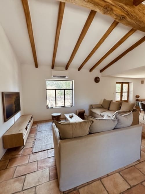 Grand séjour de villa aux poutres apparentes, sièges confortables, TV et lumière naturelle aux Villas d'A Storia