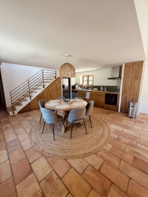 Spacieuse cuisine ouverte et salle à manger à la Casa Di I nostri villa, Porto-Vecchio, avec table ronde en bois et bleu