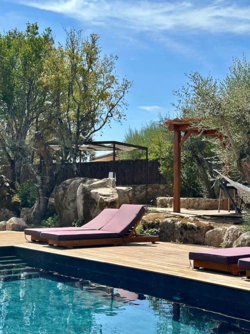 Piscine privée avec transats et terrasse en bois à la villa Casa Di I nostri à Porto-Vecchio, entourée d'arbres et de pierre