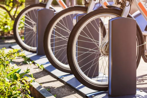 Row of blue bike-share bicycles parked at Domaine Le Piboul in Fontcouverte, sunny outdoor setting