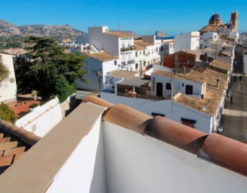 Vista de la azotea del Hostal Fornet Altea con paisaje urbano mediterráneo, tejas de barro y montañas al fondo