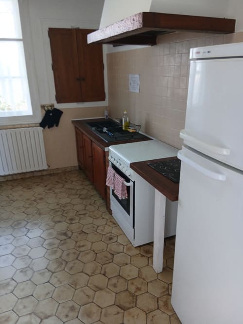 Cuisine de charme chez Robins avec cuisinière blanche, plaque de cuisson, réfrigérateur et boiseries à Trie-Château