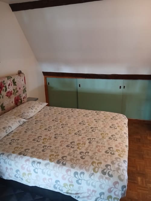 Chambre cosy du gîte Chez Robins à Trie-Château avec literie à motifs et armoire verte encastrée