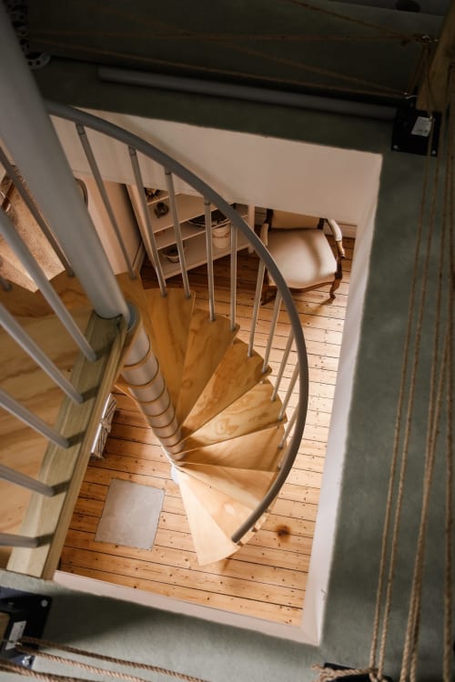 Escalier en spirale aux marches en bois et rampe métallique dans un intérieur de cottage, Oberhaslach