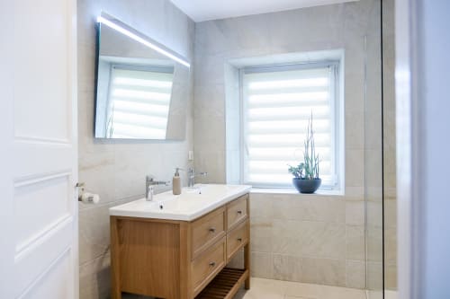 Salle de bain moderne du gîte La Maison du Gardien à Oberhaslach avec vanité en bois, miroir éclairé et fenêtre avec vue