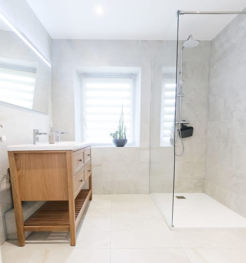 Salle de bain moderne à La Maison du Gardien aux Cabanes du Nideck avec meuble vasque en bois, douche spacieuse et lumière naturelle
